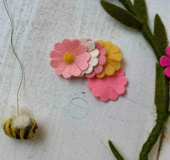 wolvilt bloemetjes in zacht roze en gele en witte tinten